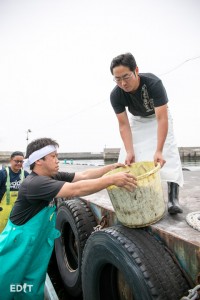 船からイカを受け取る、中山社長